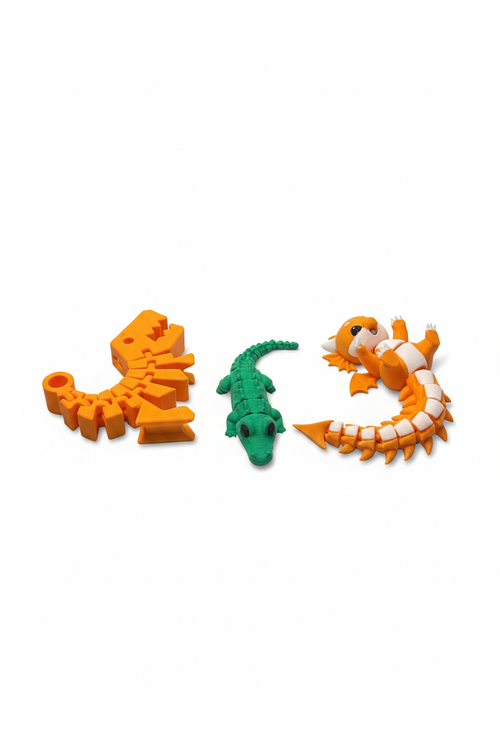 Top view of an articulated dinosaur skeleton, alligator, and dragon three-piece toy bundle on white