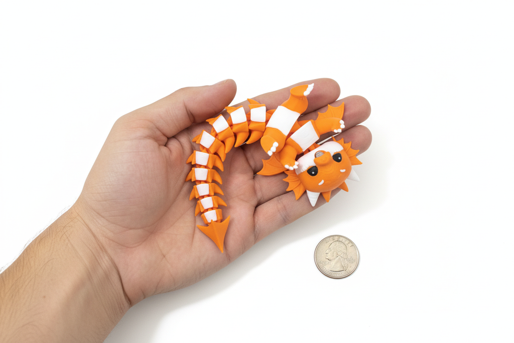 Hand holding the 3D printed articulated dragon fidget toy with a coin next to it for size reference